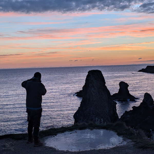Olivier photographiant les Aiguilles de Port-Coton au coucher du soleil